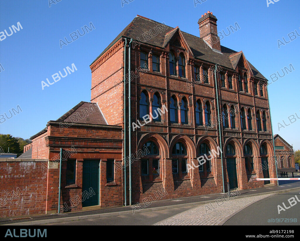 SIMON INGLIS. Black Country Living Museum, Rolfe Street Baths, Tipton Road, Dudley, 2005. The Rolfe Street Baths, originally located in Smethwick, seen from the south-east at the Black Country Living Museum in Dudley after it was moved in 1989. The baths were built in 1888 for Smethwick Board of Health. The building was designed by Harris, Martin and Harris, with ornamental brickwork and terracotta panels decorating the facade. The building housed two swimming pools, slipper baths, showers and a municipal laundry. The baths closed in 1989 and the building was dismantled and moved to the Black Country Living Museum, where it was rebuilt at the Tipton Road entrance to the site. The former swimming pool halls were converted into exhibition space and archives, which opened in 1999.