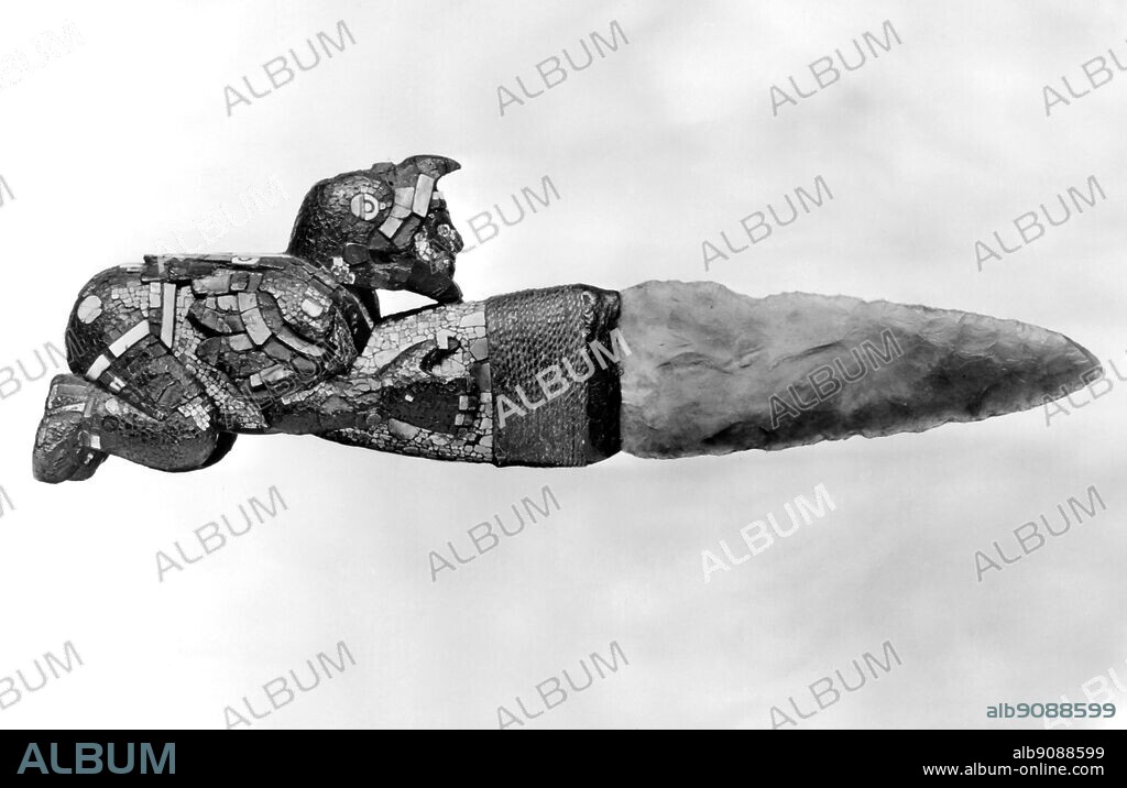 Sacrificial knife with Chalcedony blade and wooden haft ornamented with a figure of an Eagle Knight inlaid with turquiose and shell . Aztec , Mexico late 15th or early 16th Century . Believed to be part of the treasure sent home by Hernando Cortez to the Emperor Charles V .
