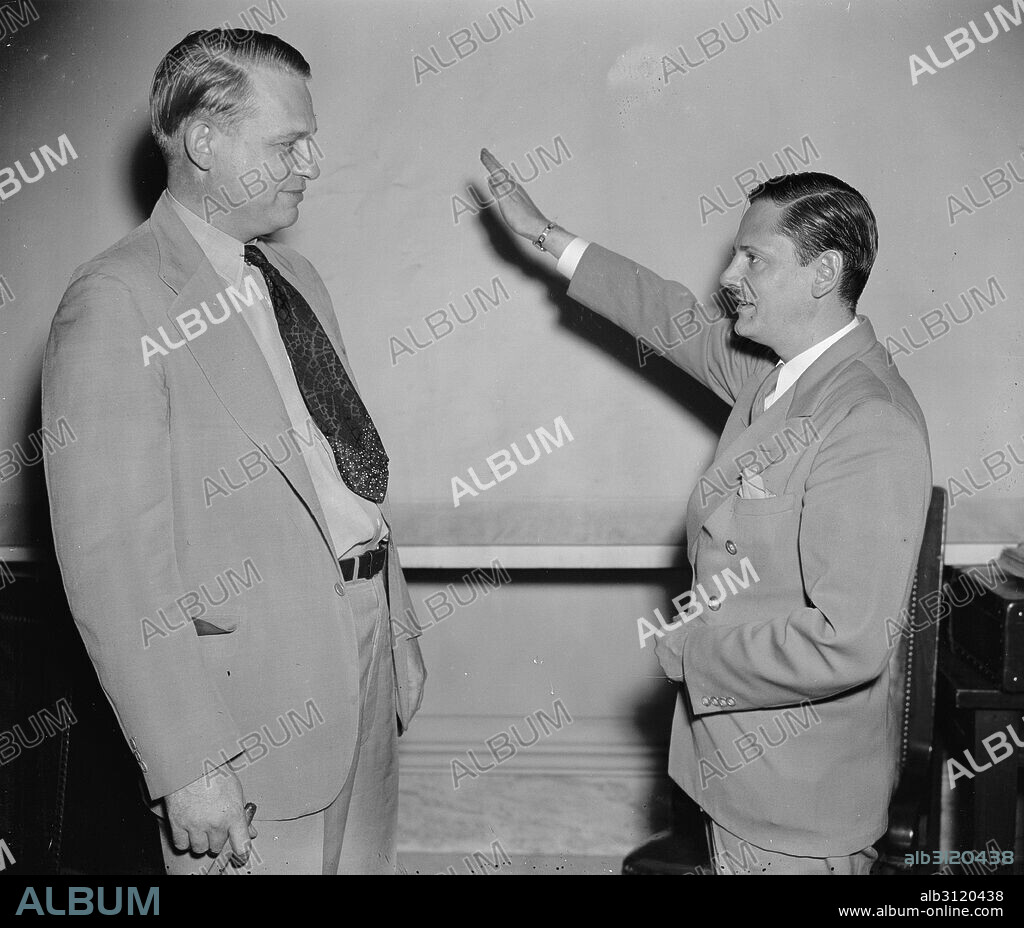 Called as the first witness before the Special House Committee investigating Un-American activities, John Metcalfe, former Chicago reporter but now an investigator for the committee, gives Chairman Martin Dies (right) a Nazi salute before taking the stand. Joining under the name of Helmut Oberwinder, Metcalfe related his experiences as a member of the German-American bund and charged the organization has a secret relationship with the Nazi government in Germany.