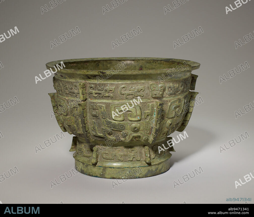 Gui food vessel, 12th century BCE, 7 × 9 15/16 in., 8.8 lb. (17.8 × 25.3 cm, 4 kg), Bronze, China, 12th century BCE, Stylized animal motifs predominate Shang bronze decoration. The dragon, snake, cicada, ram, owl, tiger, and even elephant all make appearances. Yet these creatures were almost always less important than the taotie (composite animal) mask, which typically dominates the largest or most important register of nearly all Shang bronzes. This exquisite food bowl, an early form of the gui with looped handles that became prevalent particularly in the Western Zhou dynasty, has three such masks clearly cast in high relief encircling its cauldron. Below each mask, in the foot band, are two opposing dragons shown in profile, while four similar dragons appear above each mask in the top decorative band. The exact meaning of the taotie mask is unknown. A nine-character inscription cast on the interior bottom may stand for branches of a big clan.