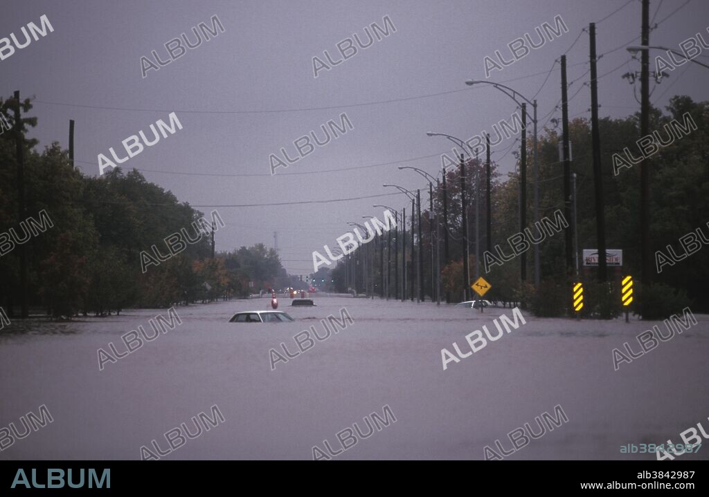Vehicles float along a flooded street in Wichita, Kansas. Heavy rains pounded the city October 31 - November 1, 1998. Known as 'The Halloween Flood of '98,' the flood remains one of the worst in Wichita history.
