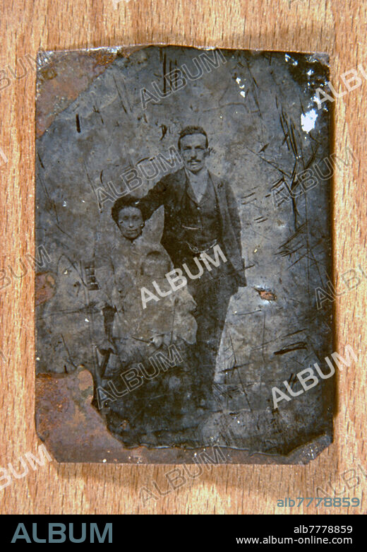 HISTORY OF PHOTOGRAPHY, Father and mother with baby in her arms. Ferrotype group: a quality of photography easily perishable. Ferrotype is a technique largely produced by itinerant photographers in the late nineteenth century. Italy, around 1870.