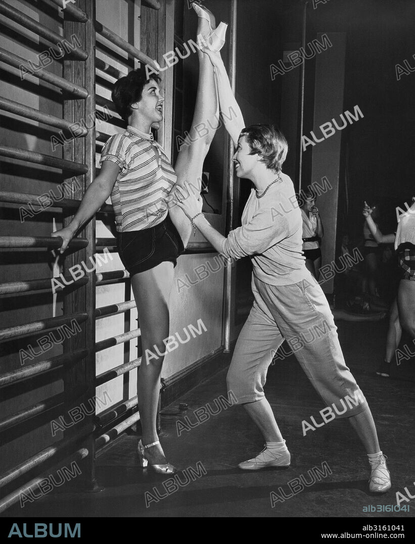 New York, New York: September 30, 1955 June Taylor personally stretches out one of her dancers so that she will be limber and loose for the next number.