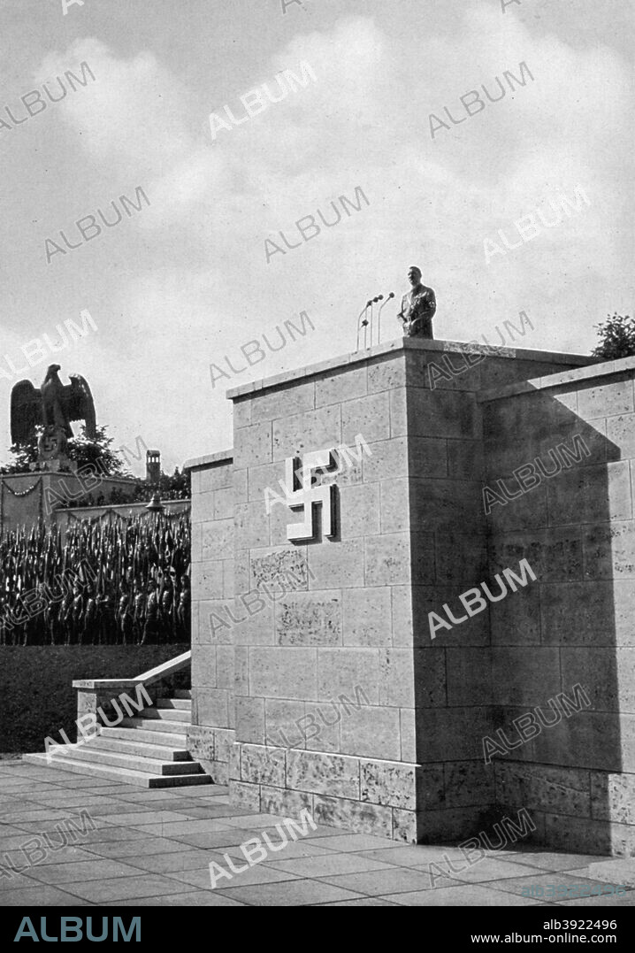 Adolf Hitler giving a speech at the Luitpold Arena, Nuremberg. Hitler (1889-1945) addressing the annual Nazi Party Congress. A print from Adolf Hitler. Bilder aus dem Leben des Führers, Hamburg: Cigaretten/Bilderdienst Hamburg/Bahrenfeld, 1936.