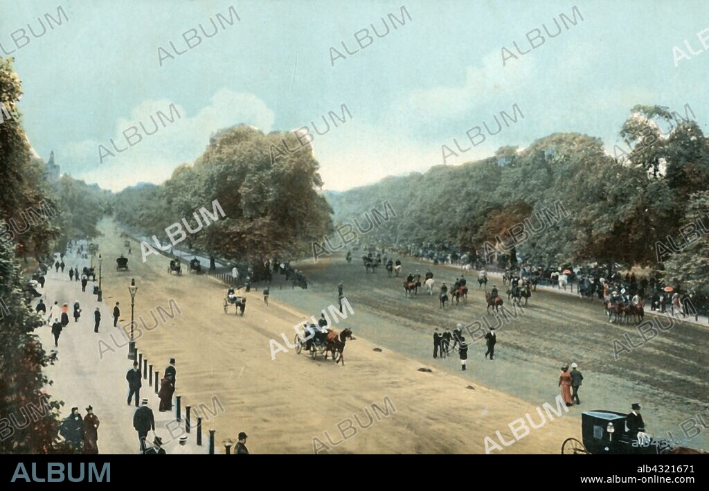 Rotten Row, Hyde Park, London, c1910. Rotten Row is a broad track running along the south side of Hyde Park. It was established by William III at the end of the 17th century. Having moved court to Kensington Palace, William wanted a safer way to travel to the previous St. James's Palace. Lit with 300 oil lamps in 1690 it became the first artificially lit highway in Britain. The track was called Route du Roi, French for King's Road, which was eventually corrupted into 'Rotten Row'. Postcard.