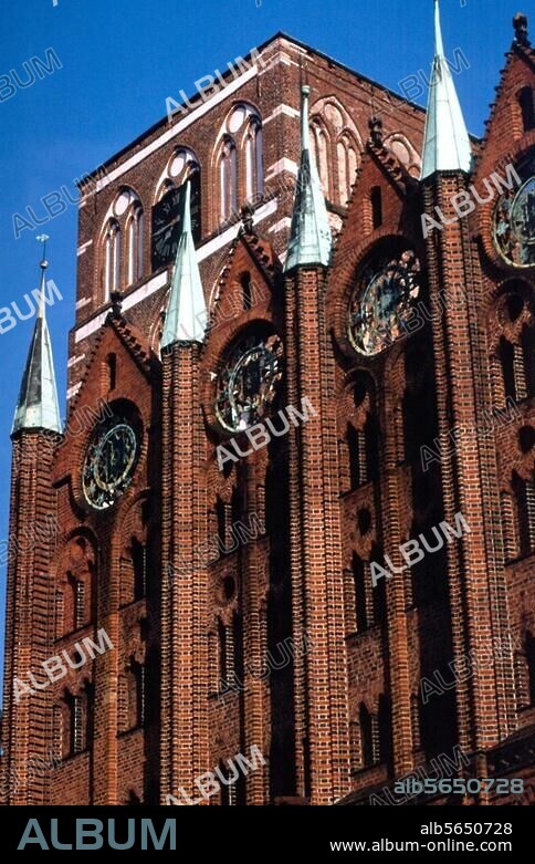 Stralsund (Meckelenburg-Vorpommern), Rathaus am Alten Markt. (gotischer Backsteinbau, 13. Jh.; Fassade 15. Jh.). Teilansicht: Ziergiebel der Rathausfassade mit Turm der Nikolaikirche.