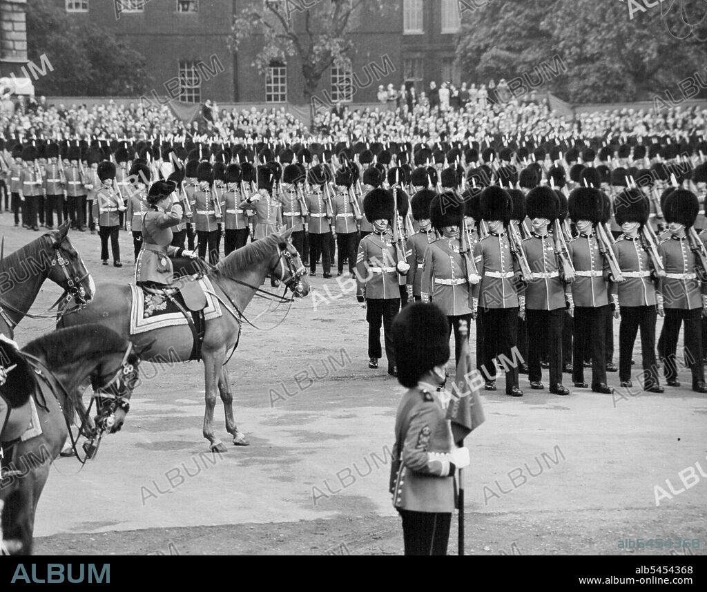 Queen taking the salute at the Trooping the Colour ceremony on horse Guards parade. The Queen rode from Buchingham palace today to take the salute at the trooping the Colour ceremony on Horse Guards parade. Record crowds lined the route to watch the Queen go by, and from the early hours of this morning people had waited on Horse Guard's parade to see the ceremony. The Queen rode side-saddle on the police horse Winston and wore her specially designed Guard's uniform - a scarlet tunic, dark blue riding skirt, and a tricorne hat with the gold badge and white plume of the Grenadiers. Behind the Queen rode Prince Philip, in fieldmarshal's uniform, and the Duke of Gloucester, Colonel of the Scots Guards. On horse guards parade, the Colour of the 1st Battalion the Grenadier Guards, the senior Guards regiment, was trooped. After the ceremony the Queen rode back along the Mall where she took a final salute at the gates of Buckingham palace. June 11, 1953. (Photo by Daily Mirror).
