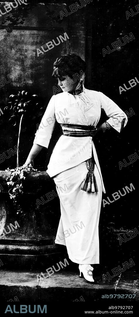Agosto 1912. La moda Femenina. Traje hechura de sastre De "Moire" Blanco, con cinturón y Caídas de seda Escocesa
Madame Magda.