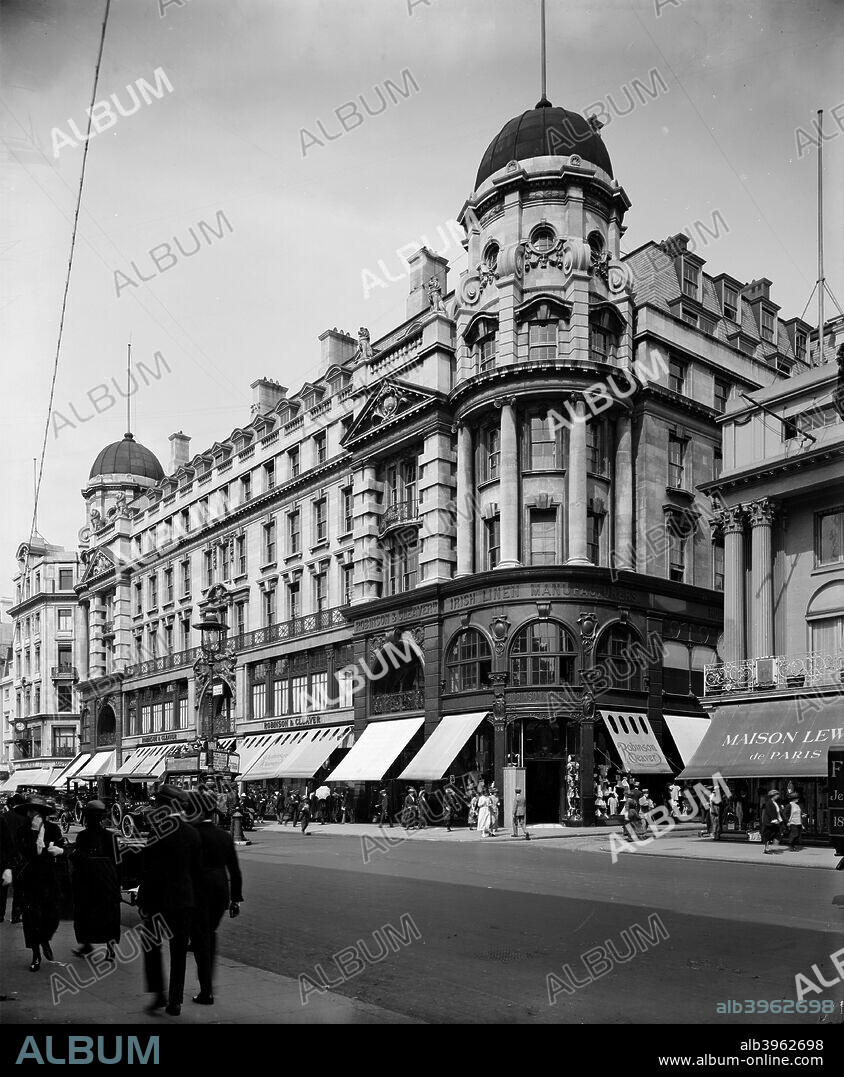 The facade of Robinson & Cleaver's department store at 156-168 Regent Street, Westminster, London 1921. The sun blinds are pulled out over the pavement as shoppers stroll past.