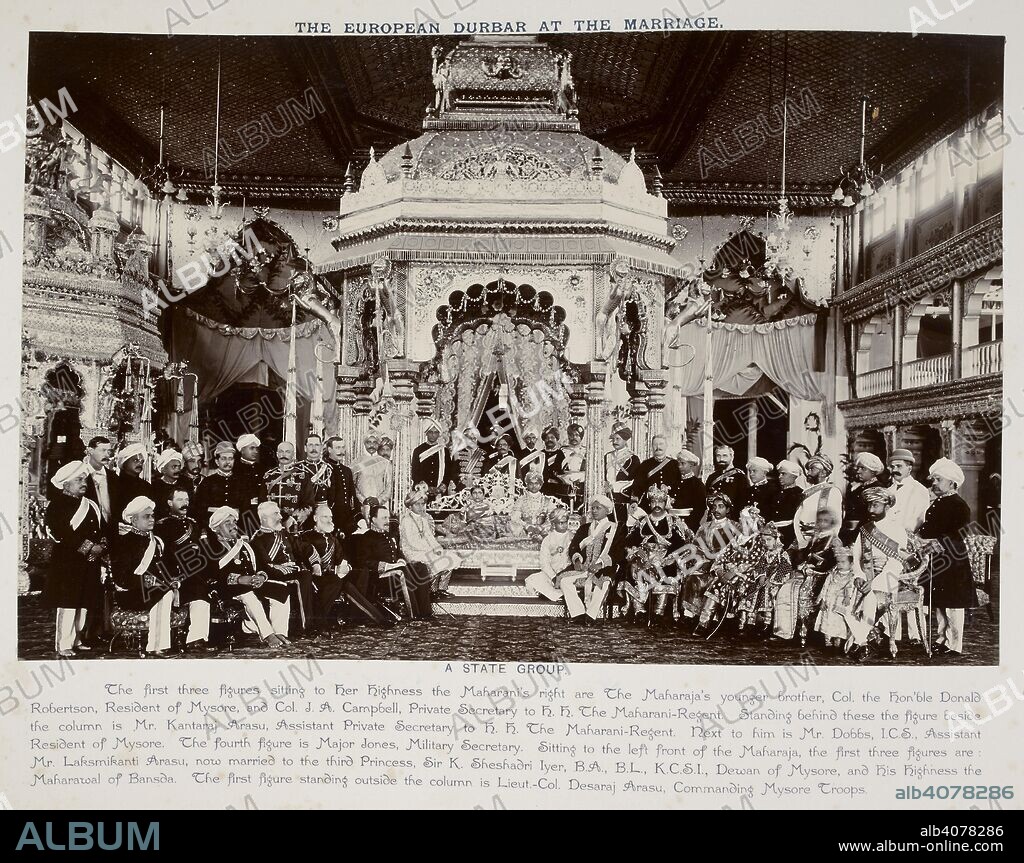 UNKNOWN. The European Durbar at the Marriage [of the Maharaja of Mysore]. A formal group portrait with Maharaja Krishnaraja Wadiyar and his bride Maharani Pratap Bai seated beneath the canopy in the durbar hall, with European and Indian officials gathered round. Curzon Collection: 'Souvenir of Mysore' Album. Jun-00. Photograph. Source: Photo 430/41(68). Language: English.
