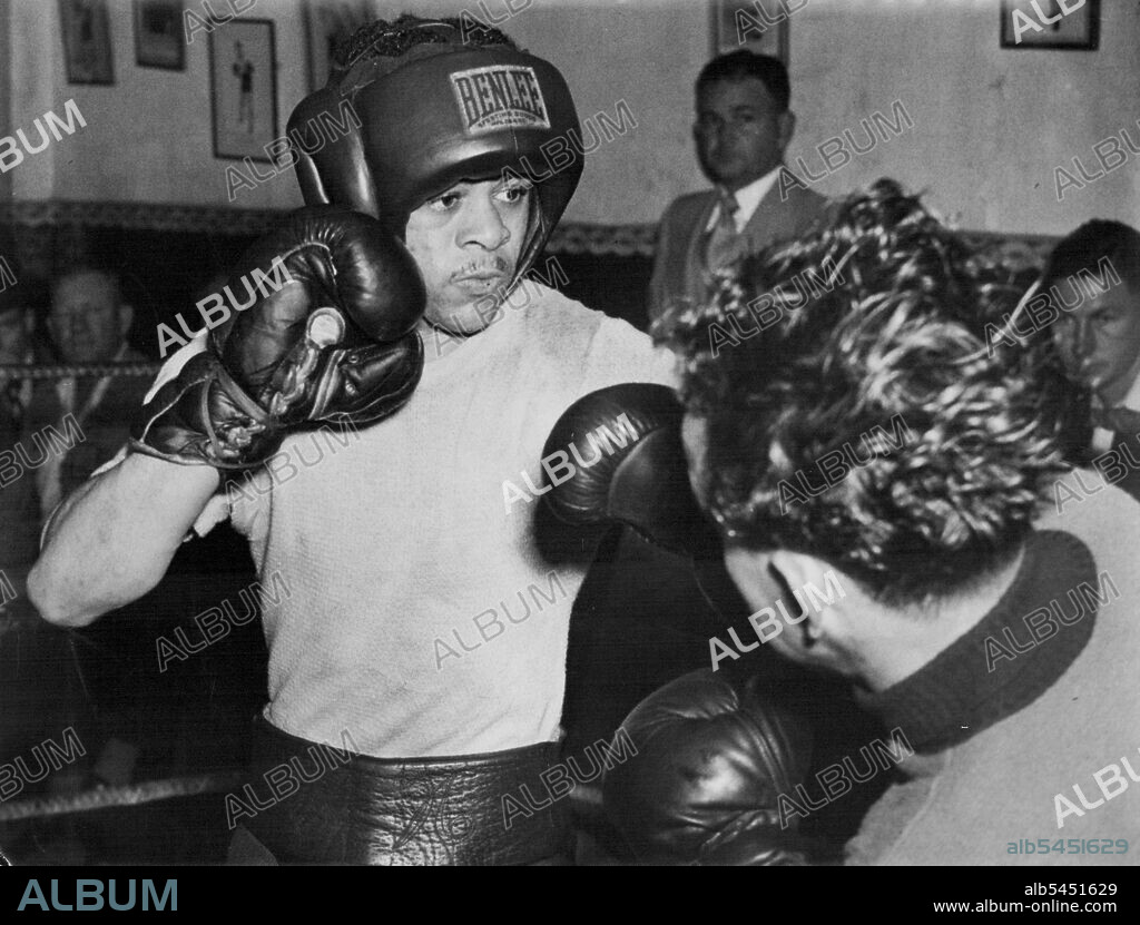 Sparring partner Charlie Dunn (right) slips inside a left hook from American bantamweight, Cecil Shoonmaker in training at Bill McConnell's gym. Shoonmaker meets Australian bantam champion, Elley Bennett, at the Stadium on Monday night. May 18, 1949.