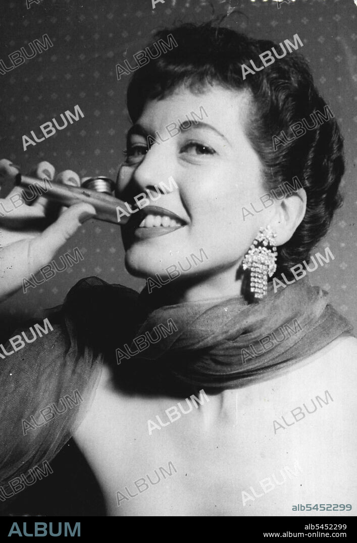 Kazoo Player from America. - Miss Paula Drake with a Kazoo after her arrival in London yesterday afternoon.
A dance the Hoocky-Koo to the magic music of a hot Kazoo" signs U.S. Cabaret star Paula Drake - just arrived in London for a season at the embassy (night) club.
Miss Drake who earns £300 a week, brought in her luggage 25 songs and two dozen Kazoos metal, torpedo-shaped instruments which, when blown, produce a comb-and-paper sound. The instruments costs sixpence. August 6, 1951. (Photo by Paul Popper, Paul Popper Ltd.).