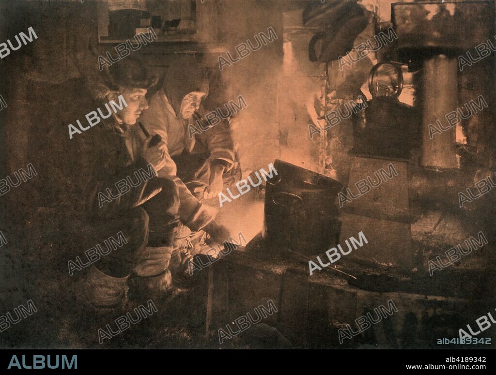 'Oates and Meares at the Blubber-Stove in the Stables', 1911, (1913). Captain Lawrence 'Titus' Oates (1880-1912) and dog-team driver Cecil Meares cooking seal blubber to feed the sledge dogs. The final expedition of British Antarctic explorer Captain Robert Falcon Scott (1868-1912) left London on 1 June 1910 bound for the South Pole. The Terra Nova Expedition, officially the British Antarctic Expedition (1910-1913), included a geologist, a zoologist, a surgeon, a photographer, an engineer, a ski expert, a meteorologist and a physicist among others. Scott wished to continue the scientific work that he had begun when leading the Discovery Expedition to the Antarctic in 1901-04. He also wanted to be the first to reach the geographic South Pole. Scott, accompanied by Dr Edward Wilson, Captain Lawrence Oates, Lieutenant Henry Bowers and Petty Officer Edgar Evans, reached the Pole on 17 January 1912, only to find that the Norwegian expedition under Amundsen had beaten them to their objective by a month. Delayed by blizzards, and running out of supplies, Scott and the remainder of his team died at the end of March. Their bodies and diaries were found eight months later. From Scott's Last Expedition, Volume I. [Smith, Elder & Co., London, 1913].