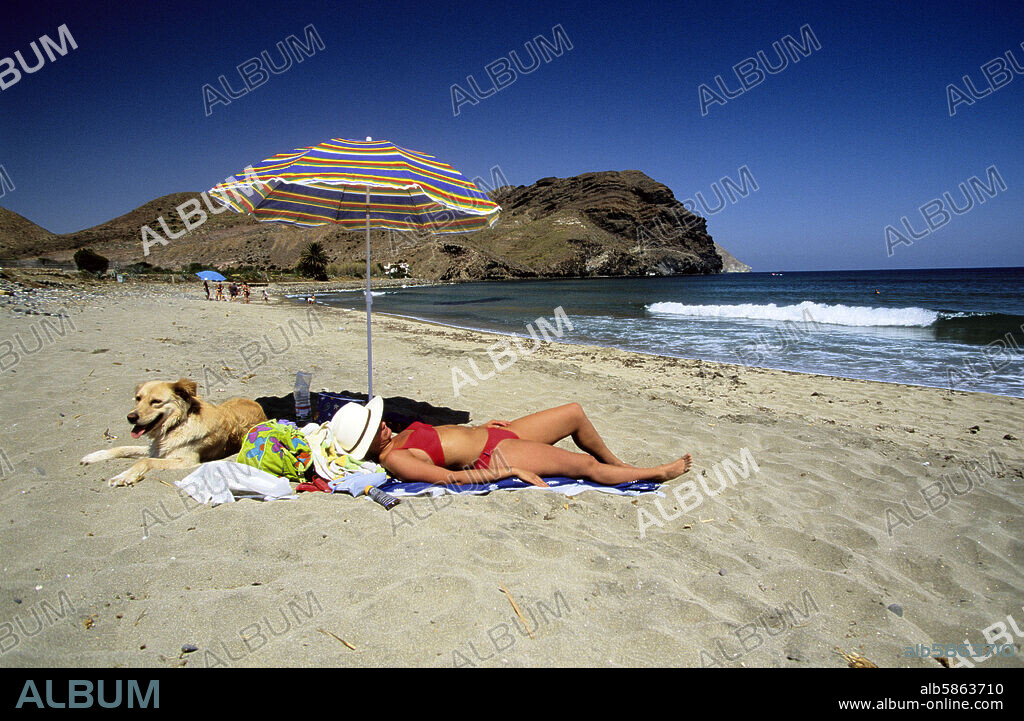 Almería - - Parc naturel Extrémité de Chat ; plage ce qui est Noires et baigneur sous parasol.