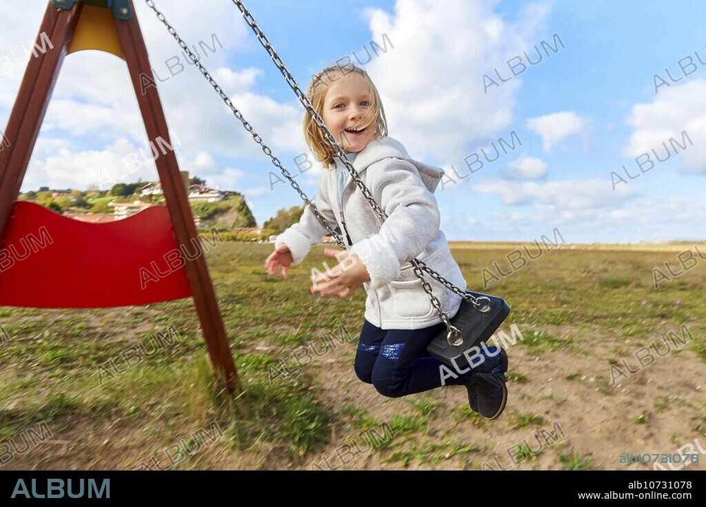 Girl playing on a swing, Zumaia, Gipuzkoa, Basque Country, Spain, Europe.