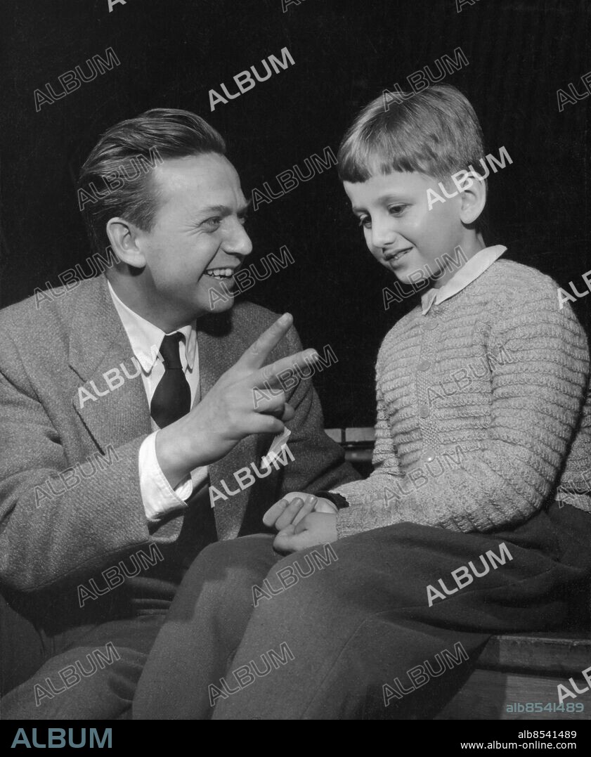 Orig. bildtext... SNURRAN DEN 20/2 55 Stig Olin med sonen Mats Anm. Publ i RiR 11/55 S Olin 1920-2008, skådespelare, regissör, sångare, radioman och låtskrivare. M Olin 1947-, Far och son Leenden Gester V-tecken Blyghet Fingrar Stickade tröjor CD496 persons: STIG OLIN;MATS OLIN sites: SVERIGE;STOCKHOLM.