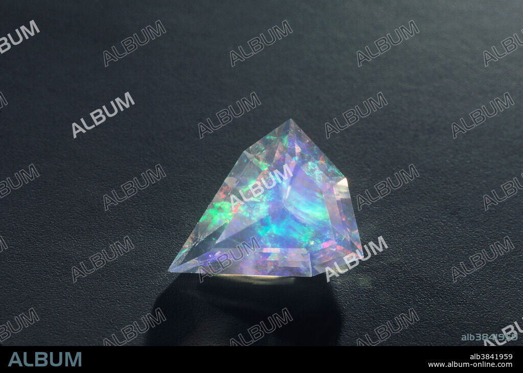 Contra-luz opal. This type of precious opal is transparent (crystal opal) and shows a different play of color (fire) when viewed by reflected light versus transmitted light. This freeform faceted gemstone is from Mexico.