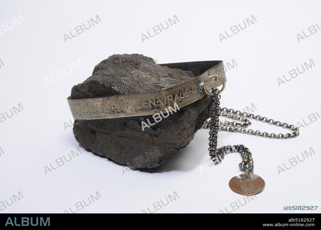 Anonymous, 1574, copper, peat, silver, General: 5.6 x 52 x 7.6cm (56 x 520 x 76mm), Peat: 5.5 x 8.8 x 6.3cm (55 x 88 x 63mm), Bracket: 1.2 x 52 x 6.8cm (12 x 520 x 68mm), Peat set in a silver bracket with a silver chain attached to it with a copper emergency coin. According to tradition from the time of Leiden, appalled. On the bracket is engraved the text: A QUESTION GODS DON'T SIT IT AND CONNIH SIE SELDE BOER SA THE TVRF WAS FOUND ANNO 1574., 1874.