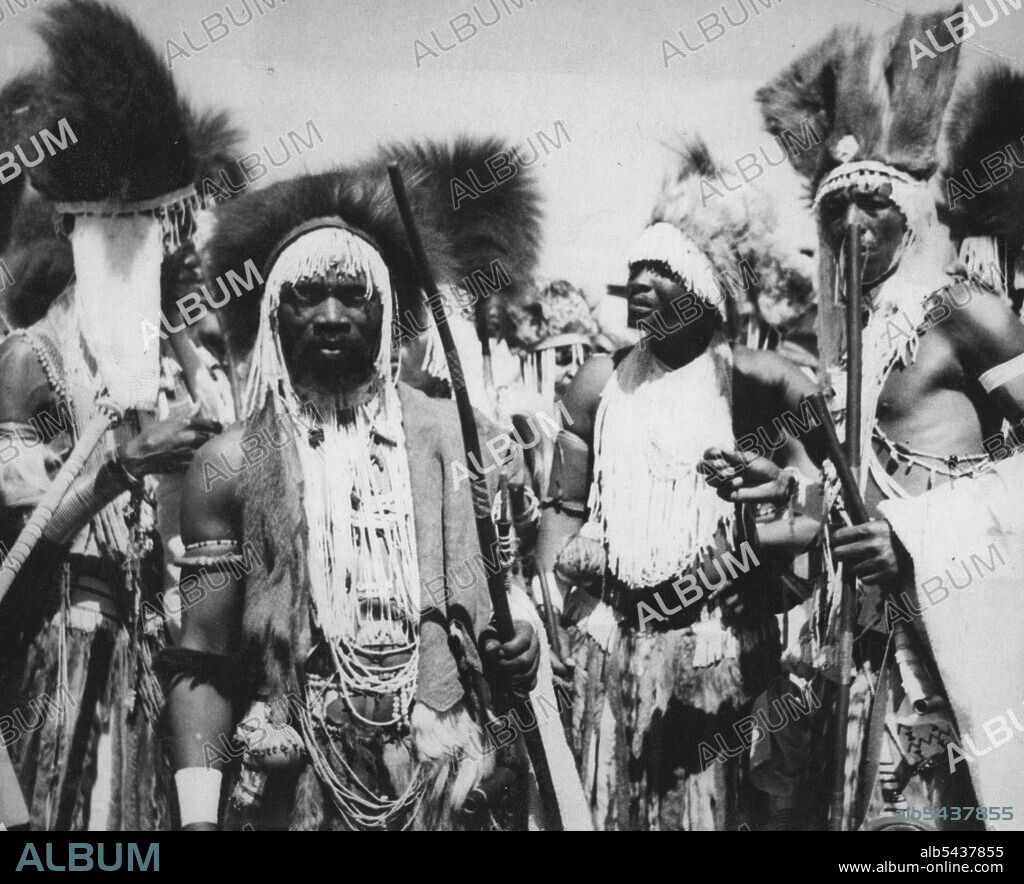 Royal Tour Of The South Africa: Visit To New Brighton -- Natives(described as "Witch Doctors") in ceremonial attire who were among the thousands who greeted the Royal Family during their drive through New Brighton. After making the acquaintance of their native subjects at Port Elizabeth, the Royal Family drove in procession through many miles of streets in New Brighton, predominantly occupied by families of the Xosa and other native Bantu races. These people turned out in thousands to line the s.