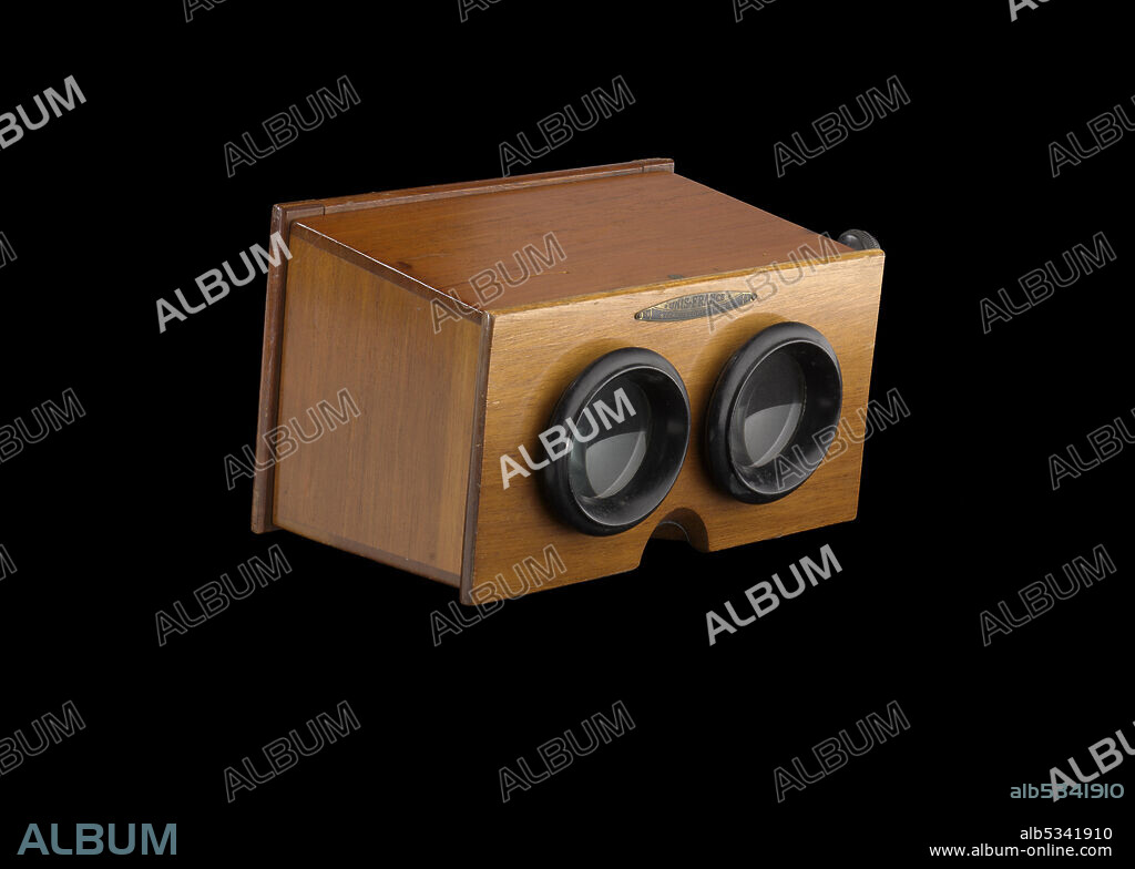A. MATTEY. Stereoscopes, dating from 1832, were devices for viewing a pair of separate stereoscopic images, depicting left-eye and right-eye views of the same scene, creating a single three-dimensional image. French stereoscope that is comprised of a wooden box with glass eyepieces and metal hardware. Above the black edged lenses is a metal plaque that reads, [76 / UNIS-FRANCE / 3 / STEROSCOPES - PARIS]. Underneath the lenses, a semi-circle is cut out of the wood for the viewer's nose. A metal turn is on the proper right of the stereoscope. A long thin rectangle is cut out to allow the metal hinge to be moved up and down. This opens the back of the stereoscope. The back door of the stereoscope is glass with wooden borders attached to the main body by a metal hinge at the bottom.