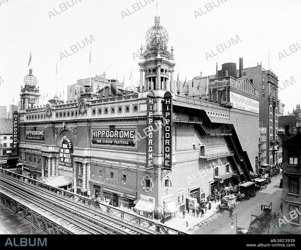 The Hippodrome Theatre was a theater in NYC from 1905-39, located on Sixth Avenue between West 43rd and West 44th Streets in the Theater District of Midtown Manhattan. It was called the world's largest theatre by its builders and had a seating capacity of 5,300, with a 100x200 foot stage. The theatre had state-of-the-art theatrical technology, including a rising glass water tank. The Hippodrome was built by Frederick Thompson and Elmer Dundy, creators of the Luna Park amusement park at Coney Island, with the backing of Harry S. Black's U.S. Realty, a dominant real estate and construction company of the time. The exterior of the red-brick and terra-cotta building was Moorish in style, with two corner towers, each of which was topped by a globe covered in electric lights. The Hippodrome's huge running costs made it a perennial financial failure, and a series of producers tried and failed to make money from the theatre. It was demolished in 1939. Photographed by F.H. Tucker, 1910.