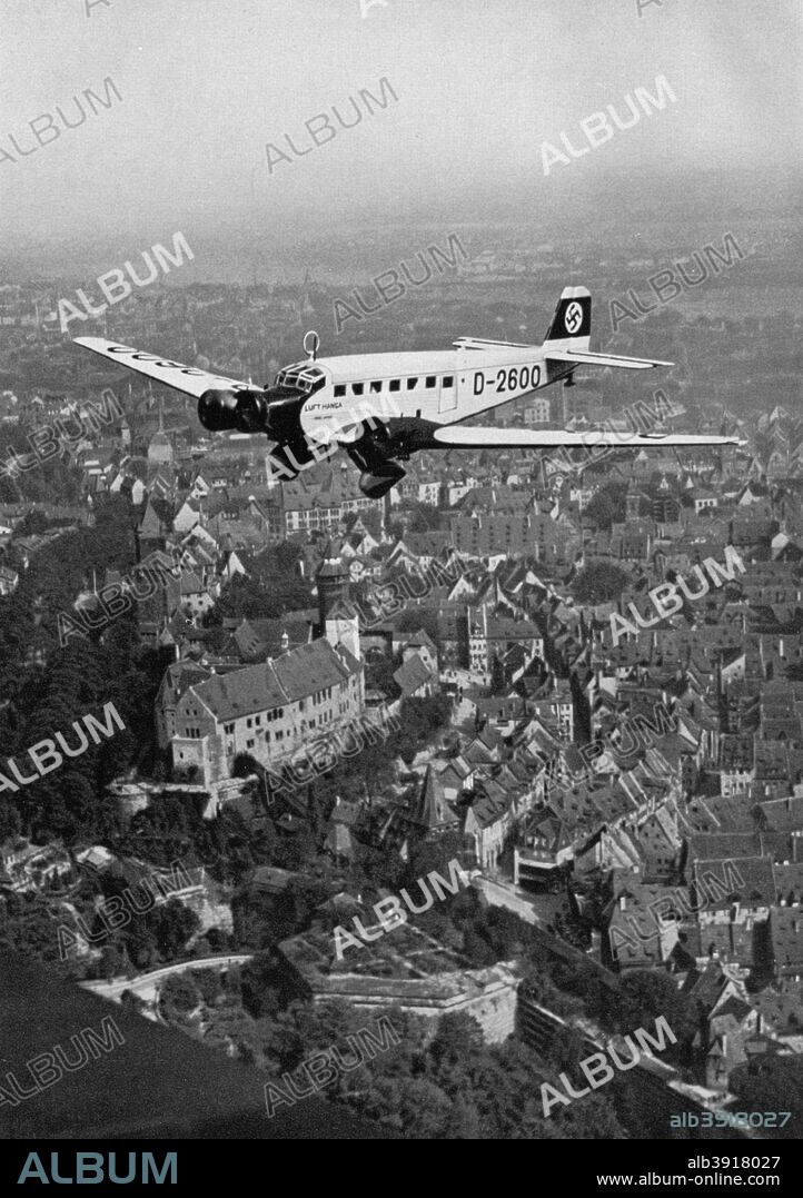 Junkers Ju 52 aircraft D-2600 over Nuremberg, Germany, 1934. The plane carrying Nazi leader Adolf Hitler (1889-1945) to the Nuremberg Rally. A print from Adolf Hitler. Bilder aus dem Leben des Führers, Hamburg: Cigaretten/Bilderdienst Hamburg/Bahrenfeld, 1936.