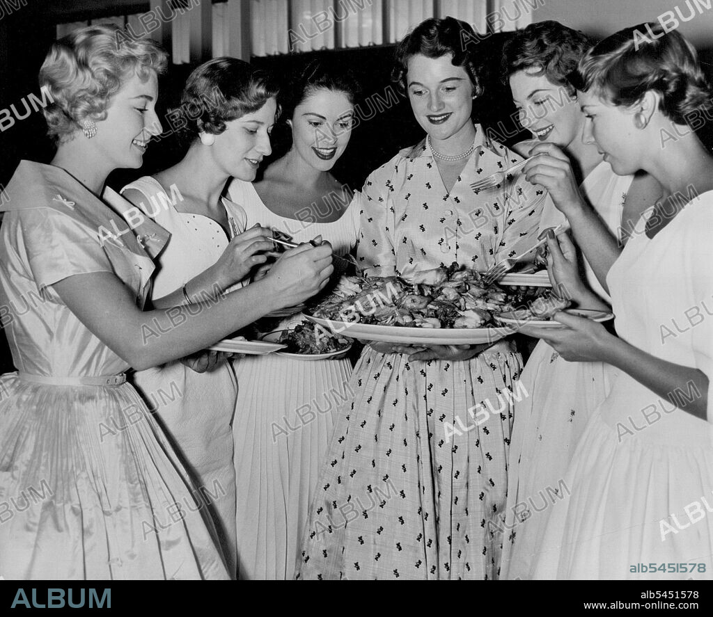 Chicken for the finalists in the 1955 Miss Australia Quest during luncheon break at the preliminary Judging in Brisbane today (Monday). From left; Miss Victoria, Miss West Australia, Miss New South Wales, Miss Queensland, Miss South Australia, and Miss Tasmania. November 10, 1955.