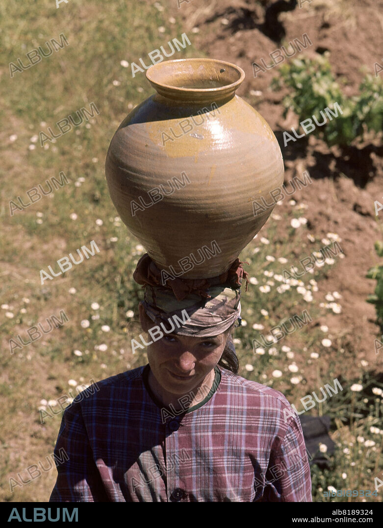 MUJER CON CANTARO A LA CABEZA CON RODELA - FOTO AÑOS 60.