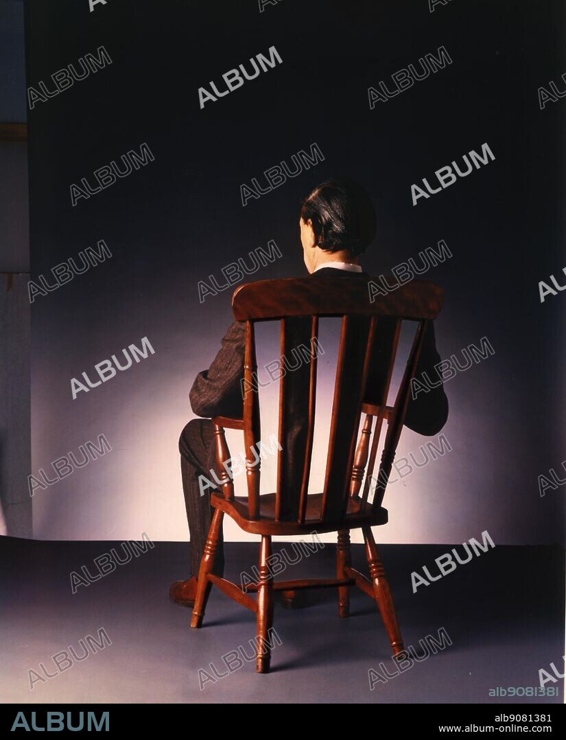 Man sitting in chair back to camera.