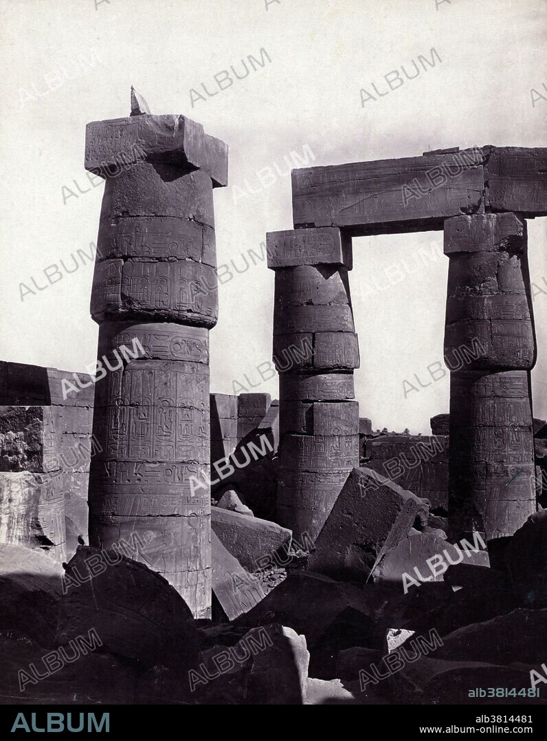 Entitled: "In Great Hall. Carnac." The Great Hypostyle Hall of Karnak, located within the Karnak temple complex, in the Precinct of Amon-Re, is one of the most visited monuments of Ancient Egypt. It was built around the 19th Egyptian Dynasty. The Karnak Temple Complex comprises a vast mix of decayed temples, chapels, pylons, and other buildings. Building at the complex began during the reign of Senusret I in the Middle Kingdom and continued into the Ptolemaic period, although most of the extant buildings date from the New Kingdom. The area around Karnak was the ancient Egyptian Ipet-isut (The Most Selected of Places) and the main place of worship of the eighteenth dynasty Theban Triad with the god Amun as its head. It is part of the monumental city of Thebes. The complex is a vast open-air museum and the largest ancient religious site in the world. The key difference between Karnak and most of the other temples and sites in Egypt is the length of time over which it was developed and used. Approximately thirty pharaohs contributed to the buildings, enabling it to reach a size, complexity, and diversity not seen elsewhere. The deities represented range from some of the earliest worshiped to those worshiped much later in the history of the Ancient Egyptian culture. Photographed by Francis Frith, circa 1856-60.