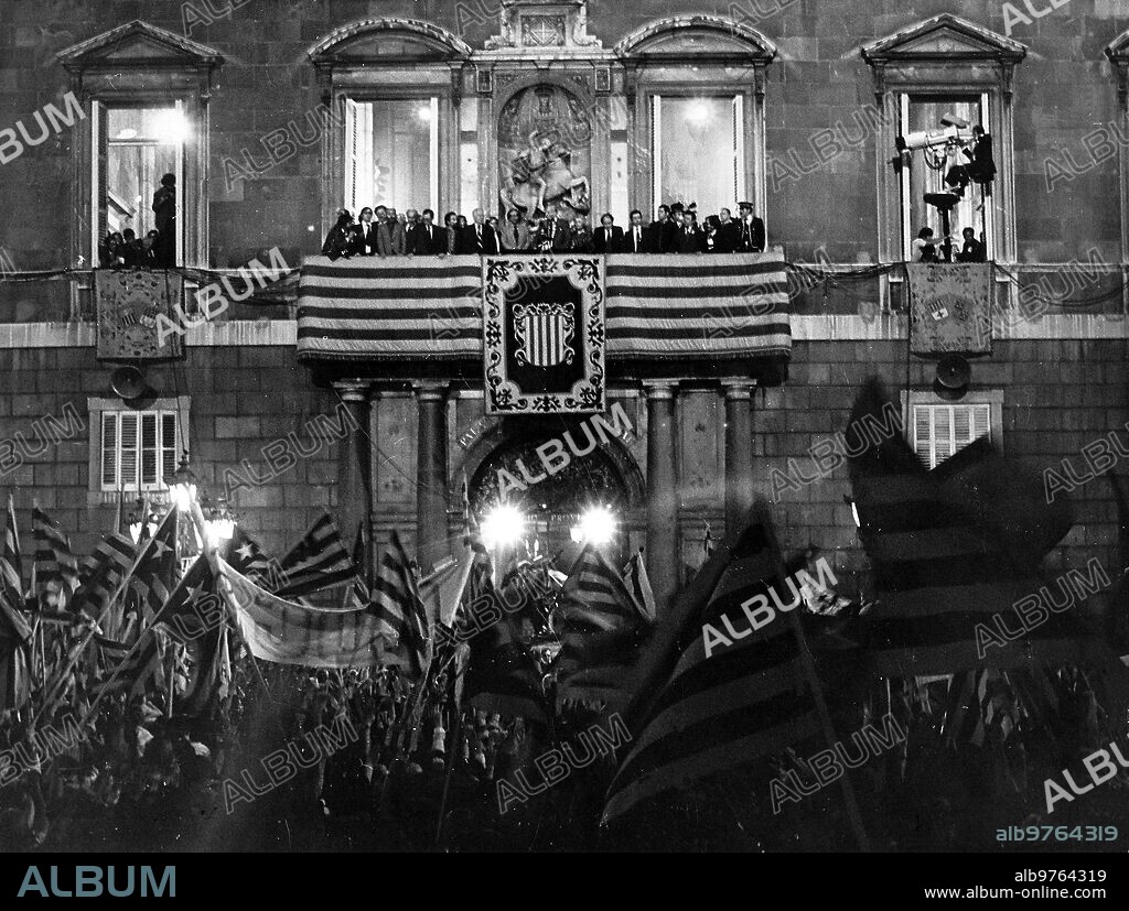 Barcelona, 23/10/1977.- El presidente de la Generalitat, Josep Tarradellas, saluda desde el balcón del Palacio de la Generalidad a las miles de personas congregadas en la plaza de San Jaime, tras su regreso a Cataluña después de treinta y ocho años de exilio. Le acompañaban, entre otros: José María Triginer, Eduardo Martín Toval; Frederic Rahola; Joan Raventós, Antoni Gutiérrez, Gregorio López Raimundo, Antonieta Maciá, Jordi Pujol y Josep Verde Aldea.