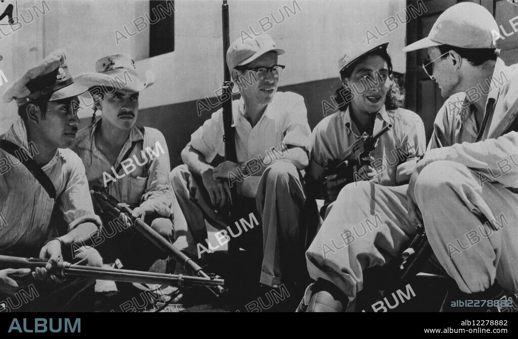 Woman Battles Reds -- Maria Trinidad Cruz, 28-year-old mother of three, whose husband was killed by Guatemalan Communists, chats with Armas liberation forces after the battle of Chiquimula. She participated in the battle. July 4, 1954. (Photo by AP Wirephoto).