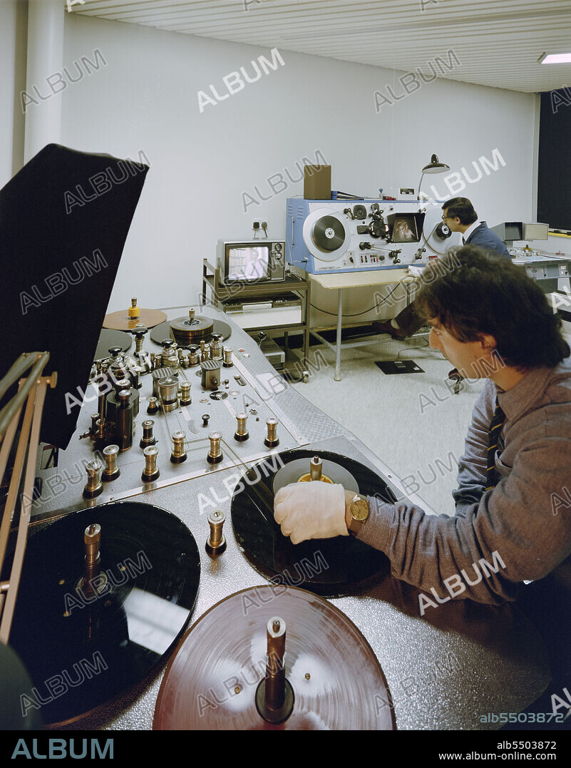JOHN LAING PLC. BFI National Archive, Kingshill Way, Berkhamsted, Berkhamsted, Dacorum, Hertfordshire, 22/01/1988. Two members of staff operating video tape machines in the new conservation centre for the British Film Institute. The new conservation centre for the British Film Institute was designed by architects Nickolls, King Design and was built by Laing's Chiltern Region. The building, which was named the John Paul Getty Jr Conservation Centre, was completed in 1987. It included a concrete single-storey storage building for nitrate film and a one and two-storey building for the restoration of film with an atrium at its centre.