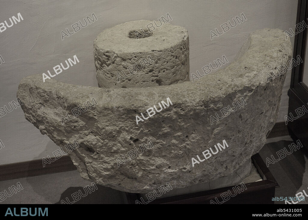 Fragmento de una prensa de piedra romana conocida como "Trapetum" (prensa de aceitunas). El dispositivo consistía en un gran cuenco de piedra (mortarium) en el que se vertían las aceitunas y luego se trituraban por medio de dos piedras cóncavas. Procede de Tas-Salvatur, en los límites de Xewkija, Malta. Museo de Arqueología de Gozo. Ciudadela de Victoria. Gozo. Malta.