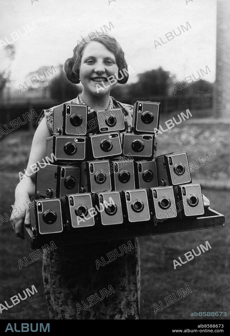 Orig. bildtext... A NEW ARRIVAL FOR THE SUMMER SNAPPER. 20.5.31. Amateur snappers this year have a new deligth, in the new Kodak No.2 Brownie that takes long distant shots and Close up portraits and this charming worker at the Kodak works, Harrow, England is seen with a delivery of the new camera. Anm. Mapp: 880A2 Kameror 1930-39 sv/v kopia Foto: Photopress/ Text & Bilder sites: STORBRITANNIEN. Bilden får endast användas i programpresenterande sammanhang. Fotografens namn, Sveriges Television samt programmets titel skall alltid anges.