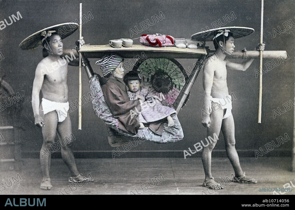 [ 1890s Japan - Japanese Kago Palanquin ] Group portrait of a mother and child in a kago (palanquin) carried by two bearers. The bearers have traditional hairstyles and wear loin cloths, straw hats and straw sandals. They are holding ikizue (breath sticks) to regulate their breathing while walking. Albumen photograph sourced by Kozaburo Tamamura (1856-1923?), 1890s. Published in "Japan, Described and Illustrated by the Japanese", Shogun Edition edited by Captain F Brinkley. Published in 1897 by J B Millet Company, Boston Massachusetts, USA. 19th century vintage albumen photograph.