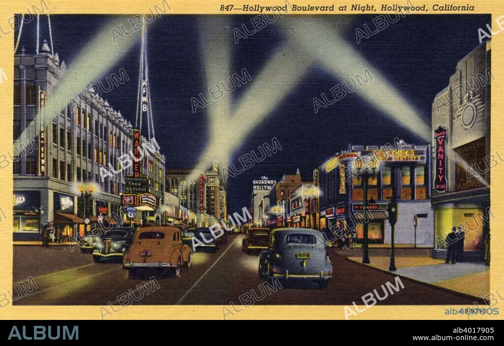 Hollywood Boulevard at night, Hollywood, Los Angeles, California, USA, 1940. Postcard. The streets are awash in neon and Klieg lights fill the sky. Cars cruise the streets and pedestrians are on the sidewalks.