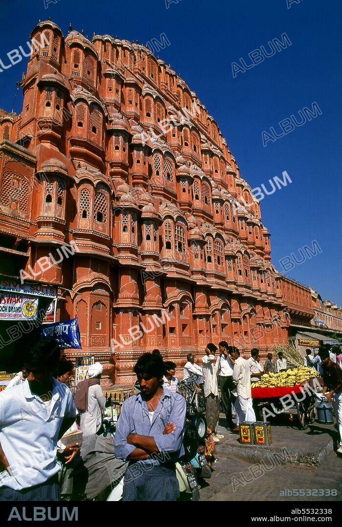 The Hawa Mahal was built in 1799 by Maharaja Sawai Pratap Singh, and designed by Lal Chand Ustad in the form of the crown of Krishna, the Hindu god. Jaipur is the capital and largest city of the Indian state of Rajasthan. It was founded on 18 November 1727 by Maharaja Sawai Jai Singh II, the ruler of Amber, after whom the city was named. The city today has a population of 3.1 million. Jaipur is known as the Pink City of India. The city is remarkable among pre-modern Indian cities for the width and regularity of its streets which are laid out into six sectors separated by broad streets 34 m (111 ft) wide. The urban quarters are further divided by networks of gridded streets. Five quarters wrap around the east, south, and west sides of a central palace quarter, with a sixth quarter immediately to the east. The Palace quarter encloses the sprawling Hawa Mahal palace complex, formal gardens, and a small lake. Nahargarh Fort, which was the residence of the King Sawai Jai Singh II, crowns the hill in the northwest corner of the old city. The observatory, Jantar Mantar, is a World Heritage Site.