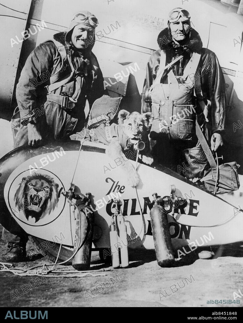 Orig. bildtext... READY FOR ATTEMPT TO BREAK PARACHUTE JUMP RECORD. Mr. Bert White, the American parachute expert, and Mr. Roscoe Turner, the Transcontinental flyer, are now preparing for a record breaking altitude flight, and parachute jump. Mr. White hopes to break the present parachute record of 24,402 feet, set up by Capt. A.W. Stevens, of the U.S. Army, at Dayton, Ohio, several years ago. Roscoe Turner hopes to reach an altitude of 29,000 feet. O.P.S. Mr. Bert White (right) the American parachute expert and Roscoe Turner, which his Lion Cub mascot, and oxygen equipment, which will accompany them on the flight. Anm. R Turner, 1895-1970, amerikansk flygare. Maskotar Mascotar Lejon Syrgastuber CD227 persons: BERT WHITE;ROSCOE TURNER sites: USA.
