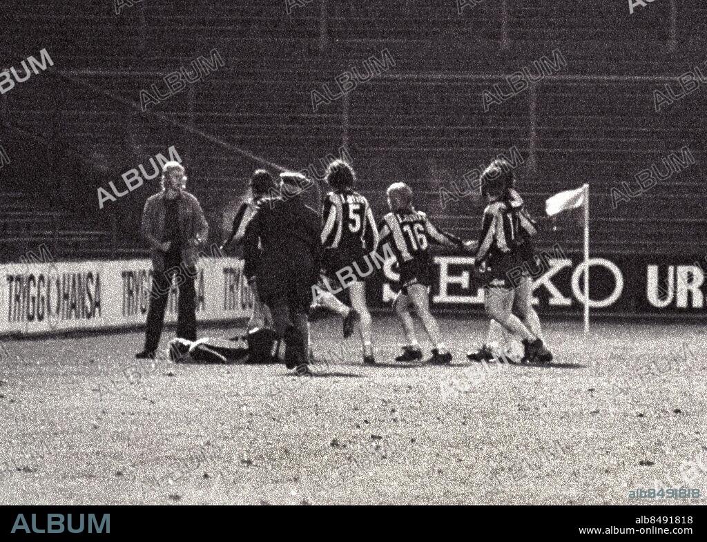 ARKIV 1973-05-17. Hammarbys Kenta Ohlsson ligger i gräset och vrider sig av smärta sedan han har fått välriktad spark mot låret av en berusad supporter (tv) som tog sig ner till planen från åskådarplats när Kenta och hans lagkamrater firade Roger Franssons 1-0 mål i det allsvenska stockholmsderbyt i fotboll mellan Hammarby IF och Djurgårdens IF 17:e maj 1973. Kenta kommenterade händelsen efteråt -Jag som trodde det var en sån där glad fyr som ville delta i pusskalaset. Hammarby vann matchen med 3-0.. Foto: Per Kagrell / XP / SCANPIX / Kod: 26. **AFTONBLADET OUT**.