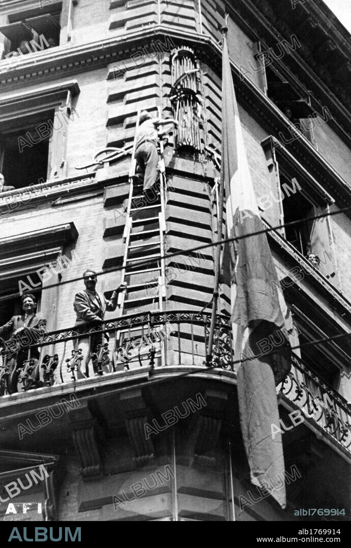 Removal of the symbols of the Fascist Party. Some men removing the fasces from the facade of a building following the fall of Fascism. Rome, 26th July 1943.