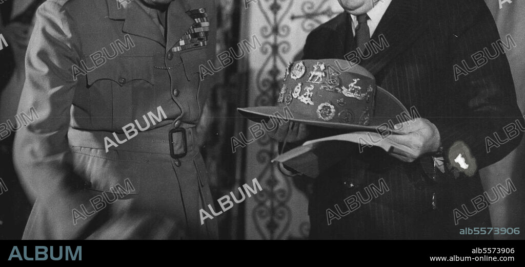 Monty Presents His Bush - Hat To Australia: At a ceremony at Australia House, Field-Marshal Viscount Montgomery presented his famous bush-hat, which bears the badges of different Army regiments, to the Rt. Hon. J.A. Beasley, High Commissioner for Australia. The bush-hat will now go to the Canberra Museum. 'Monty' and Mr. J .A. Beasley, who holds the hat. August 22, 1947.