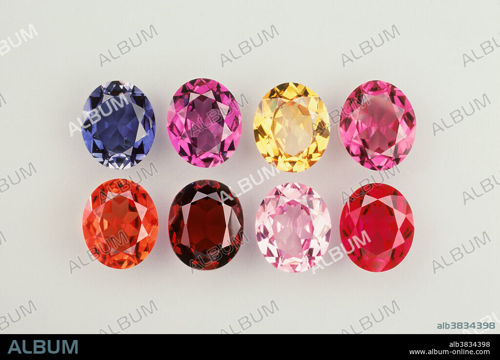 Faceted oval gemstones cut from synthetic corundum. Pure corundum, aluminum oxide, is colorless, but small amounts of chemical impurities create myriad hues. The red variety of gem quality corundum has a specific name: ruby. All other gem corundums are termed sapphire. Massive, non-gem corundum is used as an abrasive. Corundum is produced synthetically in the laboratory by a variety of methods. The synthetic (man-made) material has optical and other properties nearly identical to natural corundum.