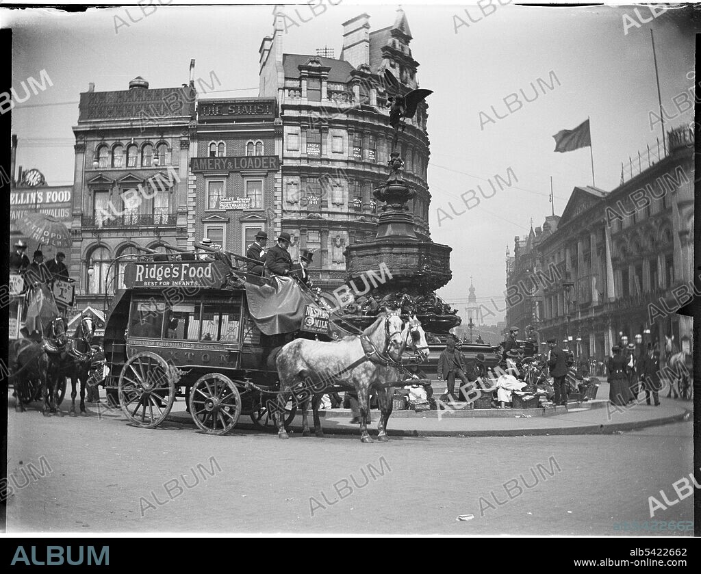 Shaftesbury Memorial Fountain, Piccadilly Circus, City of Westminster, Greater London Authority, 1895-1905. A view of Piccadilly Circus from the south-west showing horse-drawn buses driving past and street vendors seated around the Shaftesbury Memorial Fountain (also known as Eros). This photograph appears to have been taken sometime between 1895-1905 and therefore it seems unlikely that the photograph was taken by Charles William Prickett who was born in 1896. The photographs in the rest of his collection were taken between 1920-1940.