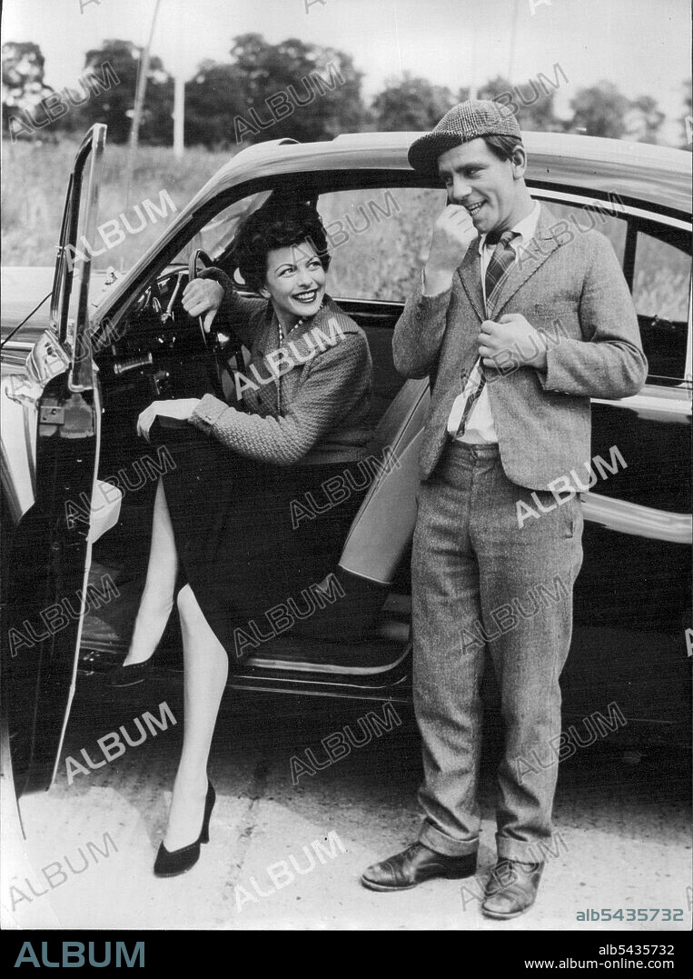 Going My Way - Bashful little man requesting a lift from actress Joan Rice is comedian Norman Wisdom. They are pictured at Pinewood Studios, where they are filming together in 'One Good Turn', Norman Wisdom's second screen comedy. The film is being produced by Maurice Cowan and directed by John Paddy Carstairs - the team responsible for Wisdom's successful first film 'Trouble in store'. August 7, 1954.