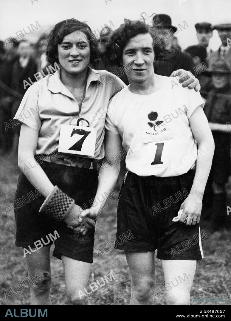 Orig. bildtext... ENGLISH GIRLS AGAIN WIN CROSS COUNTRY RACE WITH FRANCE. Englands women cross-country runners won their match with France at Selsdon (Surrey) on Saturday, so repeating the victory which they gained in France last year. Miss Gladys Lunn, the W.A.A.A. National champion, who covered the distance of nearly two miles in 12 mins. 52 secs. and gained individual honours for the second time, was followed home by Mlle. Hedouin, the young French champion, but three of the next four places were gained by English women. O.P.S. Miss Gladys Lunn chaking hands with Mlle. Hedouin, the French girl who finished second. Anm. Siffror Nummerlappar Handslag Hälsningar Stickade vantar Emblem Sju Ett Manligt utseende CD416 persons: GLADYS LUNN;SUZANNE HEDOUIN sites: STORBRITANNIEN;FRANKRIKER*.
