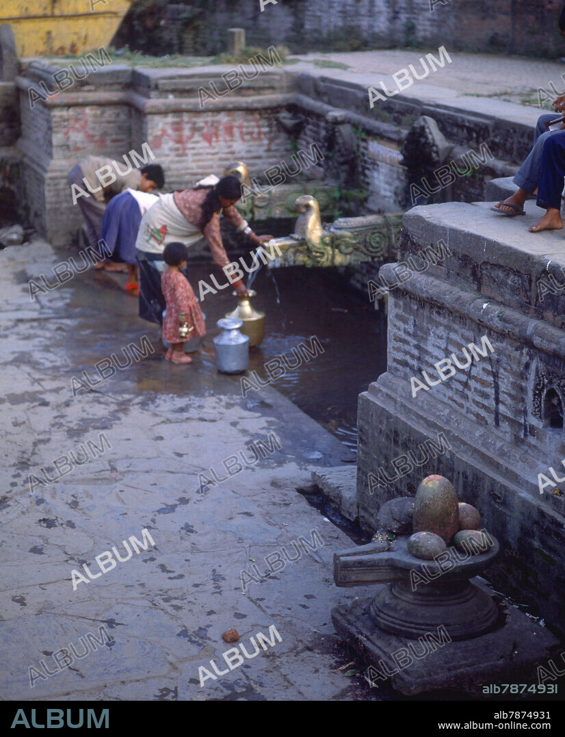 MUJER Y NIÑOS COGIENDO AGUA DE FUENTE CON CAÑOS EN BRONCE.
