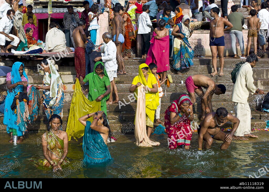 Indian Hindu pilgrims bathing in The Ganges River at Dashashwamedh Ghat in Holy City of Varanasi, Benares, India.