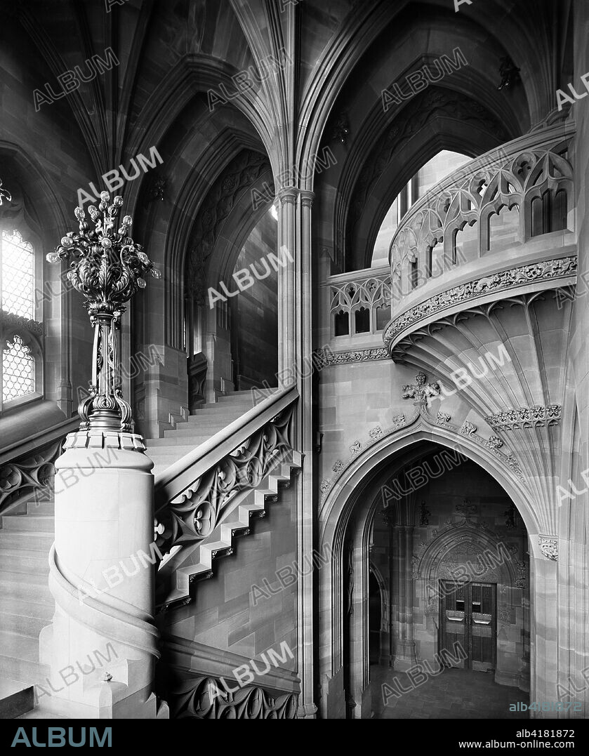 John Rylands Library, Deansgate, Manchester, 1900. Interior view, showing a staircase and architectural details as seen from a half-landing. The library was completed in 1899 to the designs of architect Basil Champneys, and was commissioned by Enriqueta Augustina Rylands in memory of her late husband, a Manchester textile manufacturer and philanthropist. The library is a fine example of Victorian Gothic Revival architecture. It later became part of the University of Manchester.