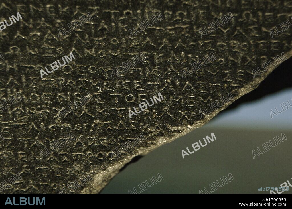 The Rosetta Stone. Fragment of a black granite stele with an inscription in different languages __of a decree of Ptolemy V Epiphanes king. Greek scripture. Detail. Ptolemaic era. 196 BC. British Museum. London. United Kingdom.